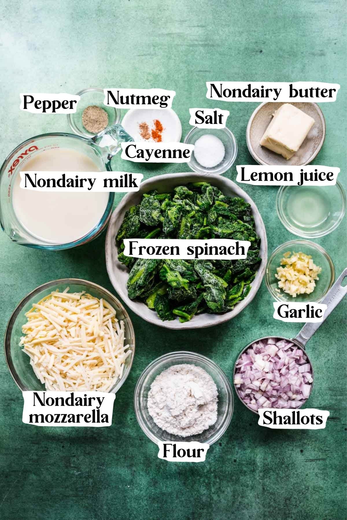 Overhead shot of creamed spinach ingredients, including shallots, spinach, garlic, and spices.