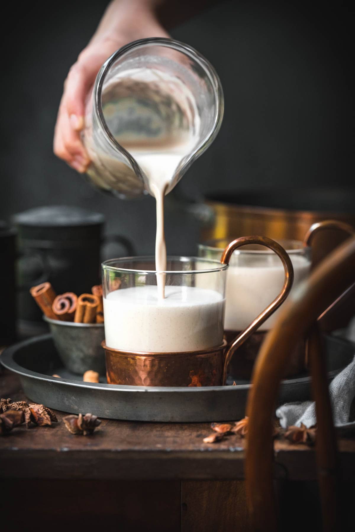 Vegan eggnog being poured into a glass.