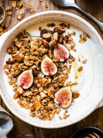 almond granola on top of yogurt with fresh figs and honey.