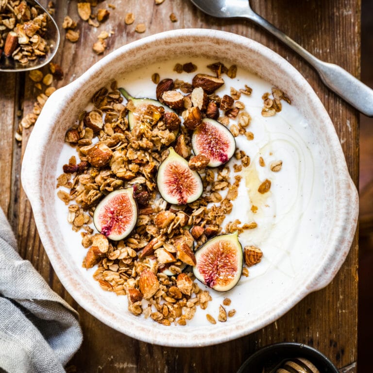 Crunchy granola and fresh figs in yogurt bowl.
