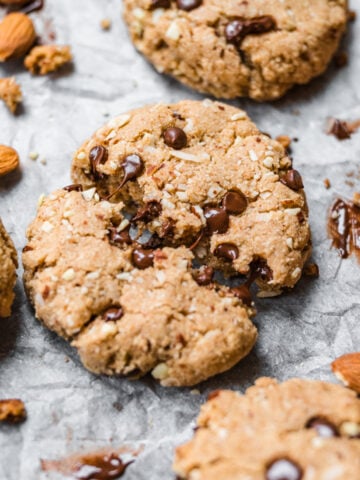 close up view of chocolate chip almond flour cookie broken in half with melted chocolate showing.