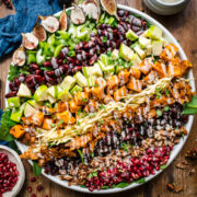 overhead view of vegan fall cobb salad on a large salad plate on wood table.