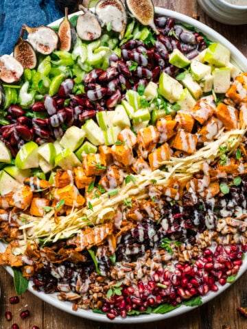 overhead view of vegan fall cobb salad on a large salad plate on wood table.