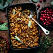 Overhead view of cornbread stuffing in a pan with a serving spoon.