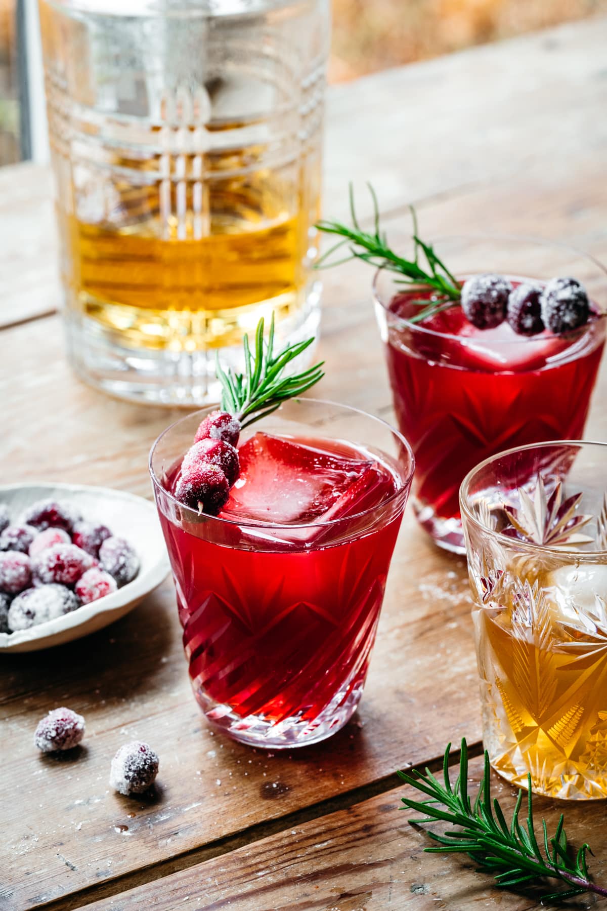 Front view of Christmas old fashioned garnished with cranberries and rosemary.