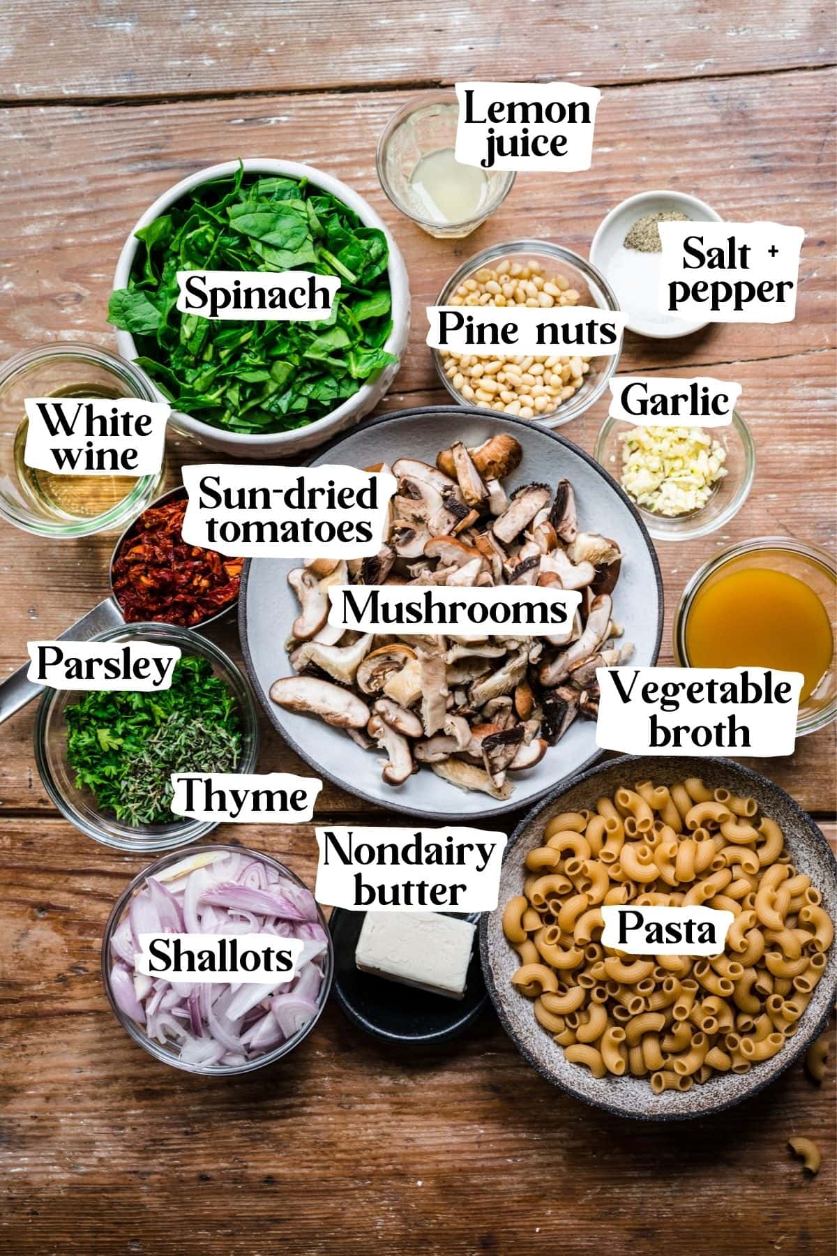 Overhead view of mushroom pasta ingredients, including spinach, mushrooms, and pasta.