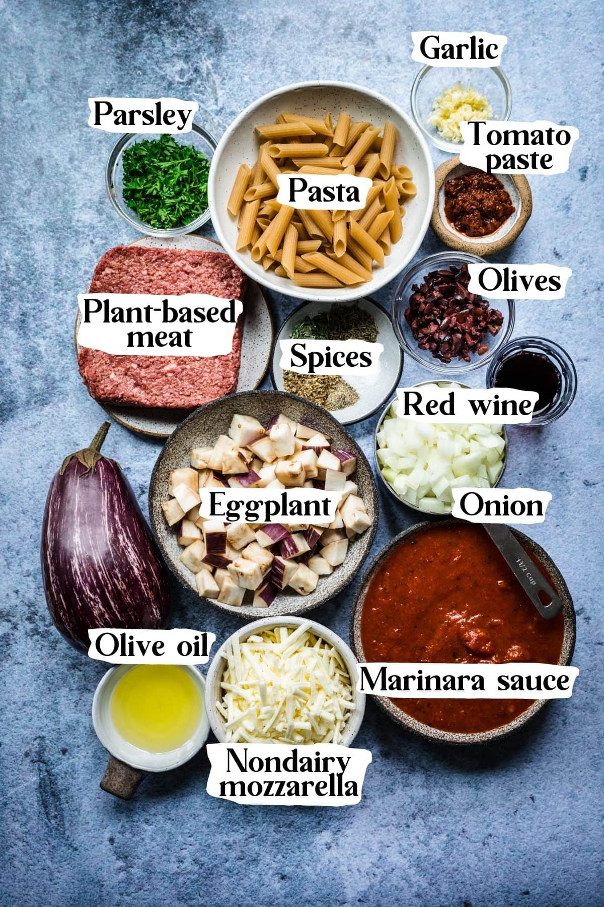 Overhead view of pasta al forno ingredients, including marinara sauce, pasta, and olive oil.