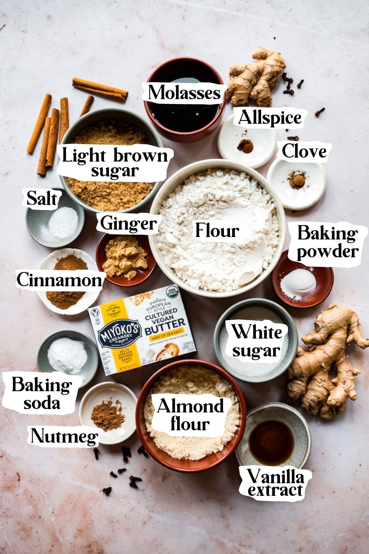 Overhead view of vegan ginger cookie ingredients, including flour, almond flour, sugar, and ground ginger.