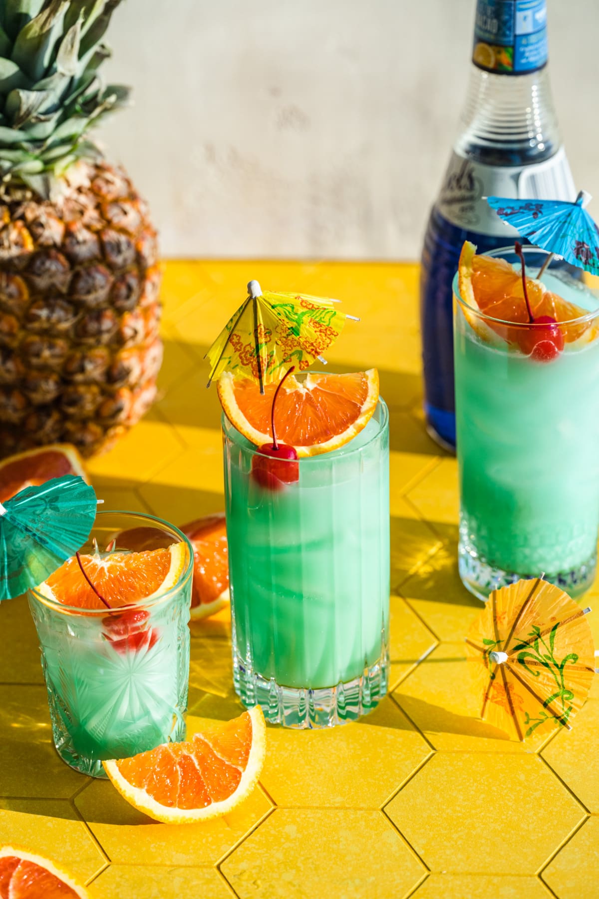 Front view of blue hawaiian cocktail garnished with orange.