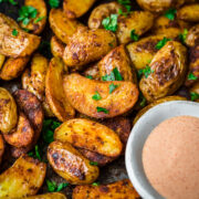 Close up of cajun potatoes with dip on the side.