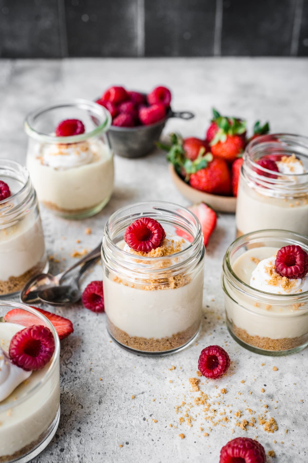 Overhead view of cheesecake in a jar with a raspberry garnish on top.