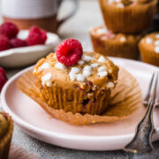 Front view of raspberry white chocolate muffin on a plate.