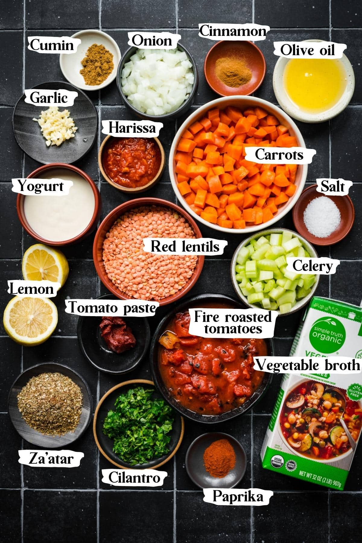 Overhead view of ingredients for spicy carrot and lentil soup in small prep bowls. 