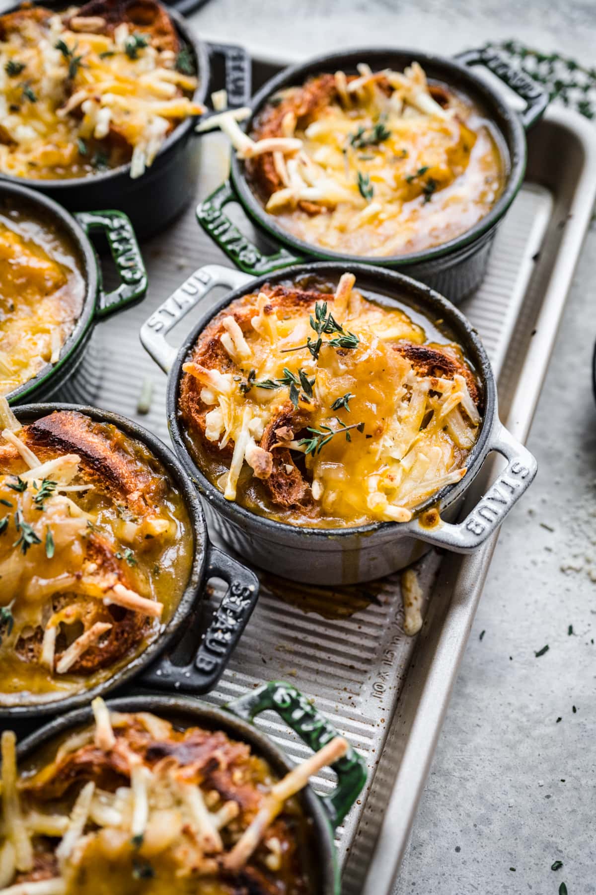 close up view of vegan french onion soup in cocottes. 