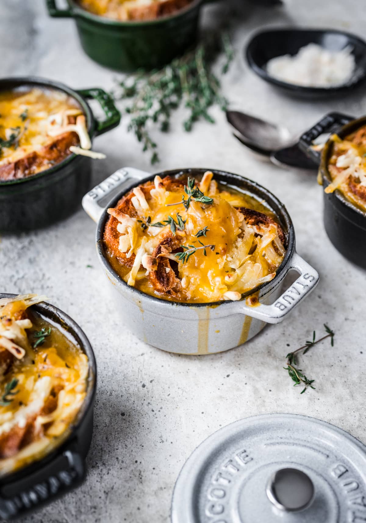 Front view of french onion soup in a crock with cheese melted on top of it.