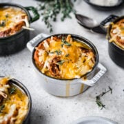 Overhead view of a crock of french onion soup with melted cheese on top.