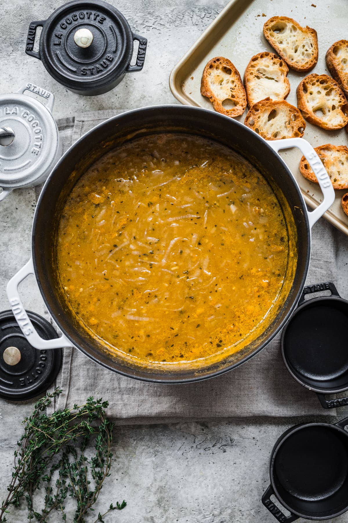 overhead view of vegan french onion soup in large pot. 