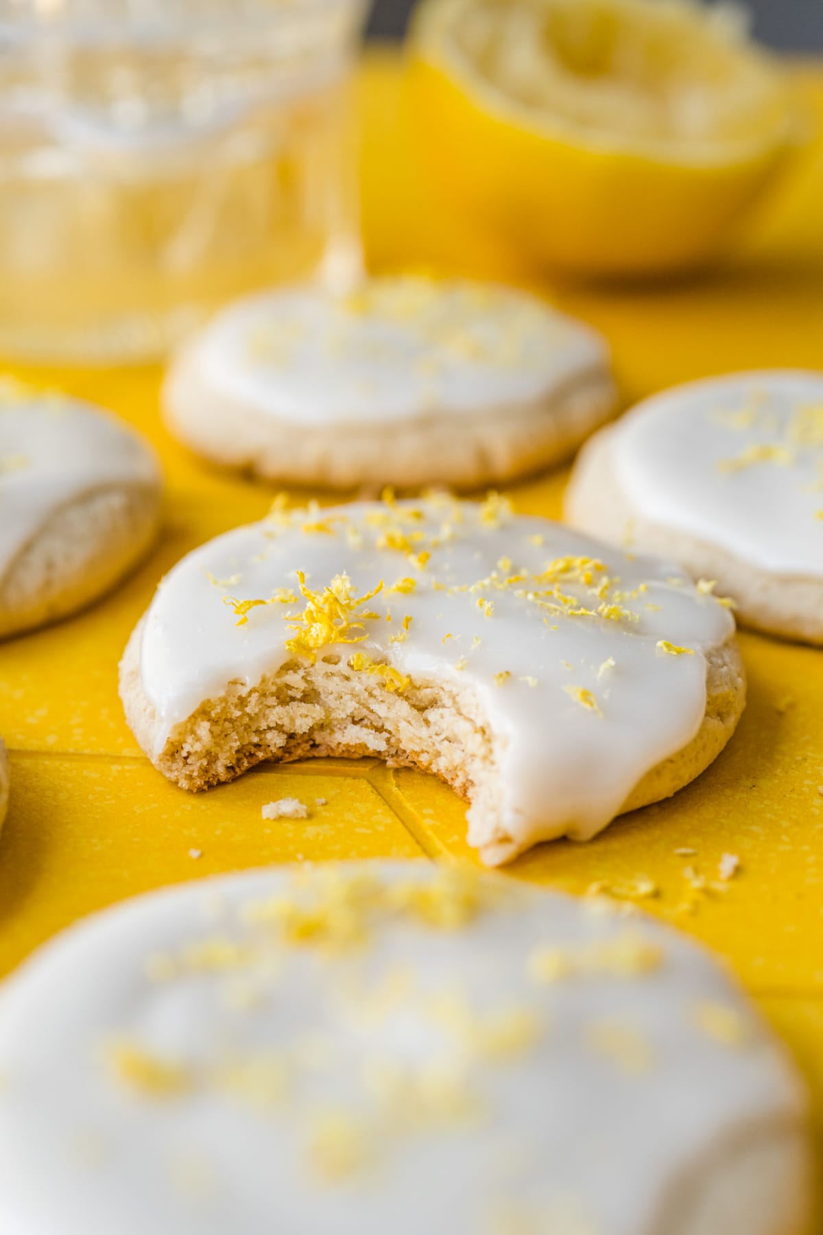 Front view of vegan lemon cookie with a bite taken out of it.