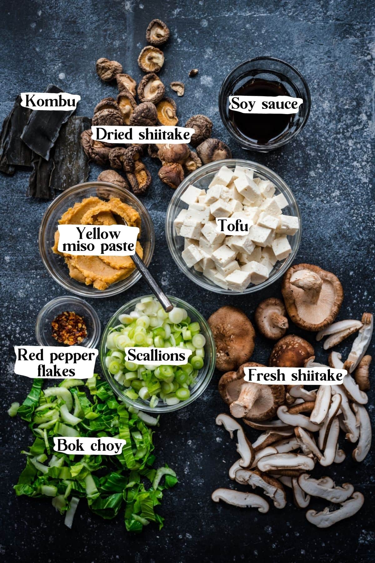 Overhead view of vegan miso soup ingredients, including shiitake mushrooms and scallions.