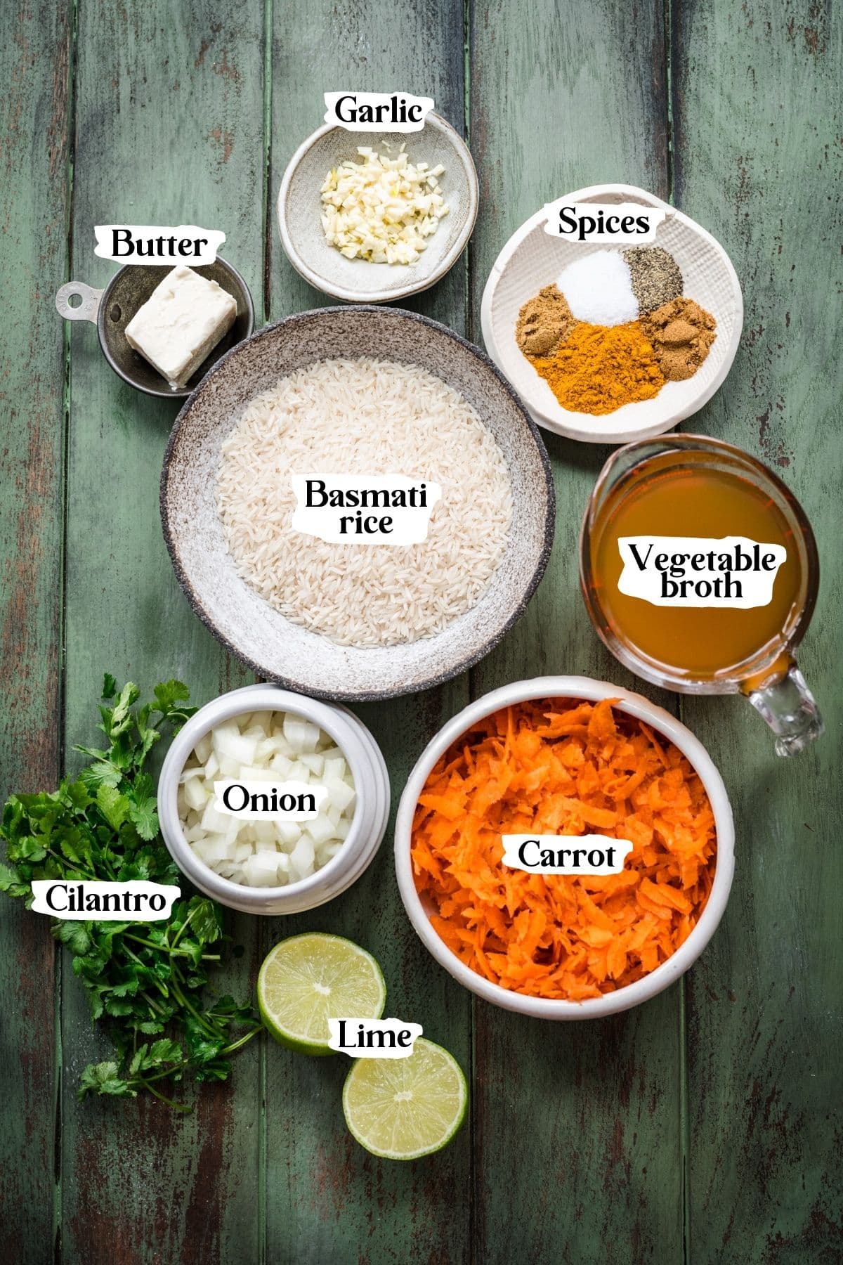 Overhead view of carrot rice ingredients, including spices, basmati rice, and vegetable broth.
