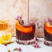 Front view of cherry old fashioned in front of a tile background.