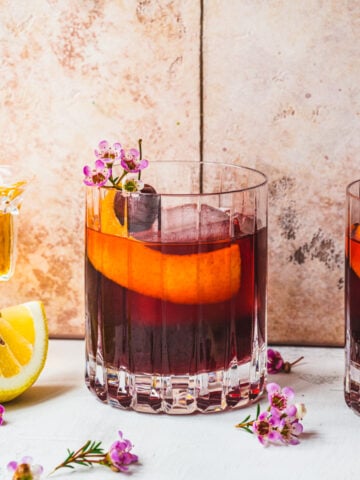 Front view of cherry old fashioned in front of a tile background.