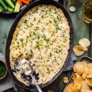 Overhead view of spinach artichoke dip in a pan.