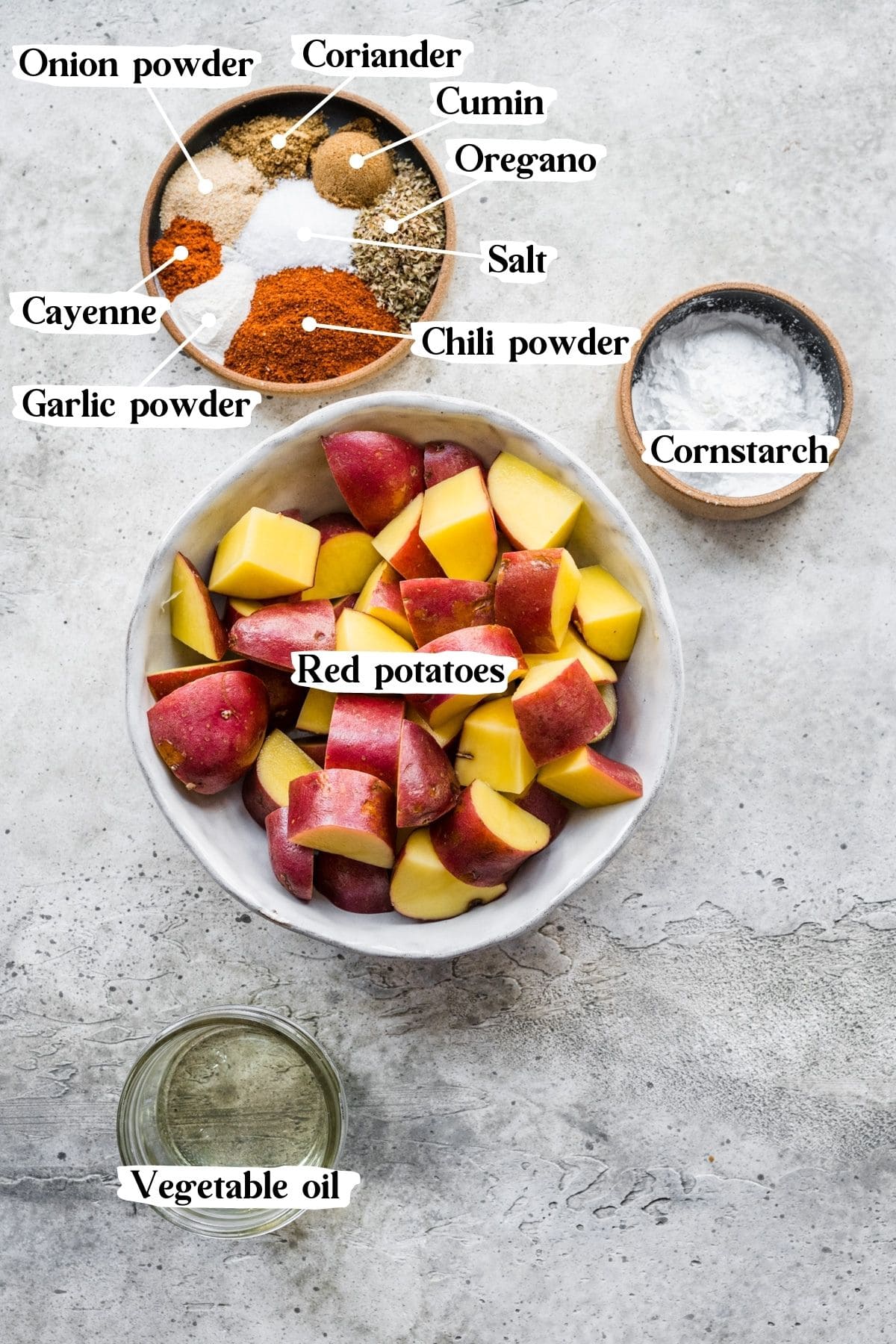Overhead view of Mexican potato ingredients, including red potatoes and spices.