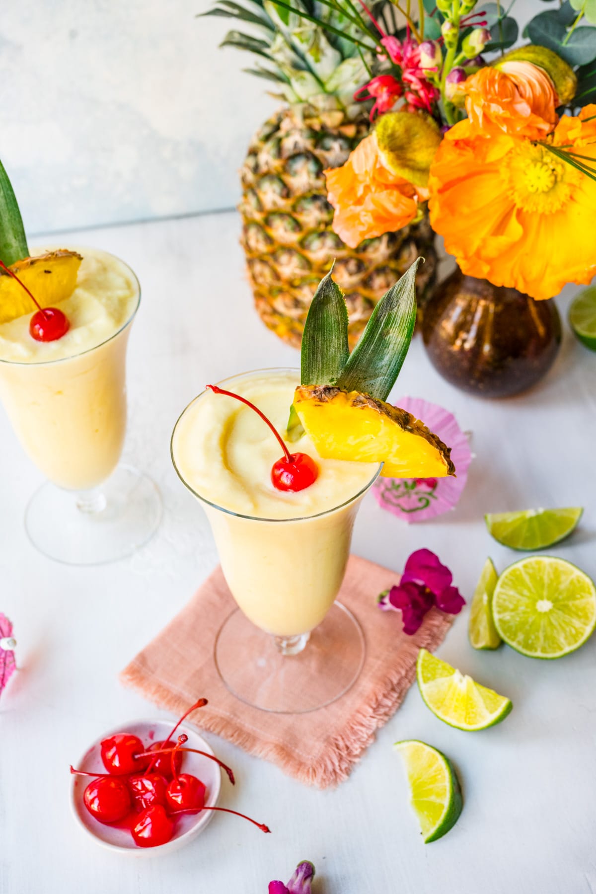 Pina colada mocktail in tall glass with maraschino cherry and pineapple. 