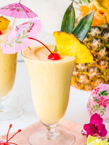 Front view of pina colada mocktail with pineapple and cocktail umbrella.