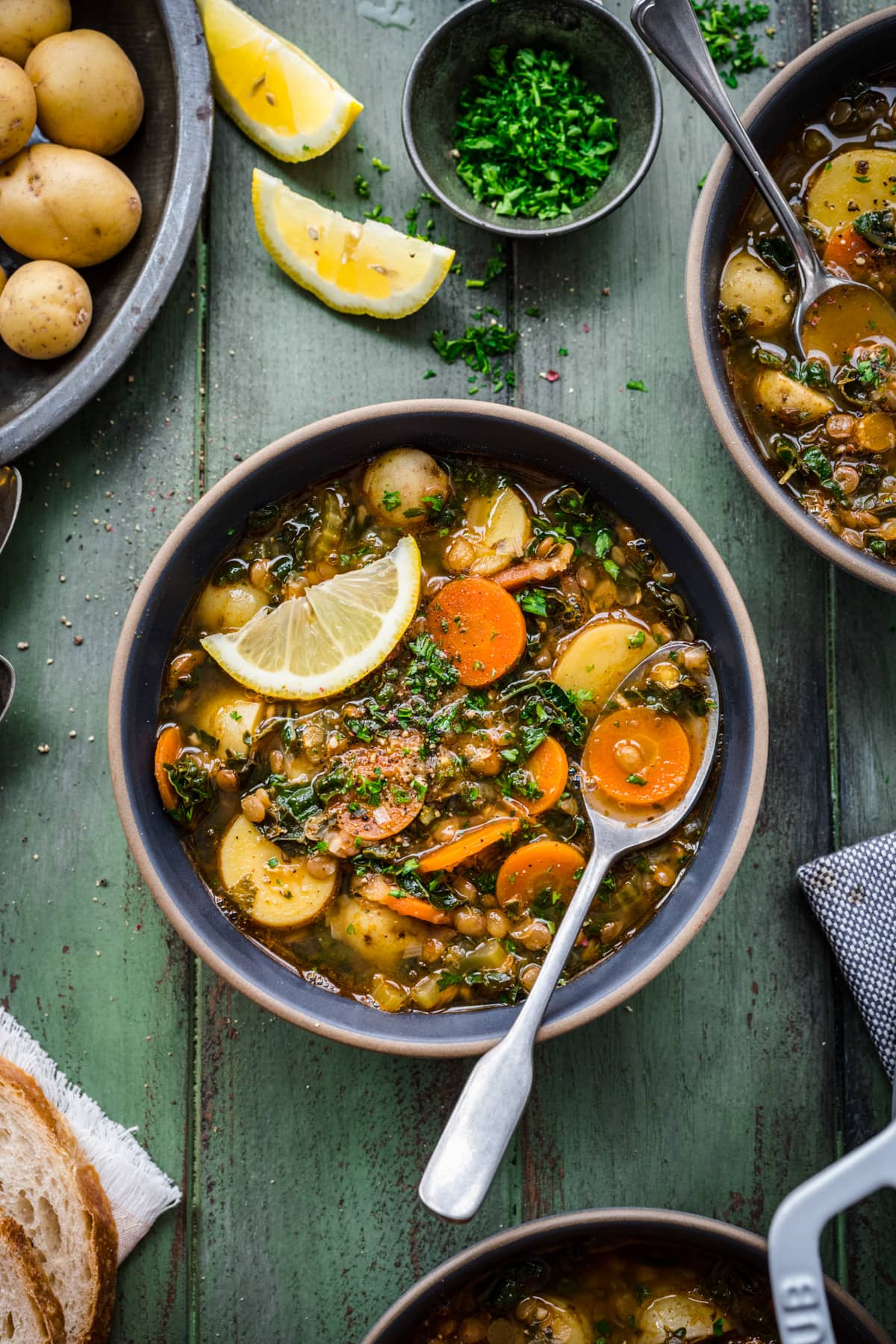 Overhead view of a bowl with potato lentil soup with a spoon in the bowl.