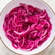 Overhead view of pickled red onions in a bowl.