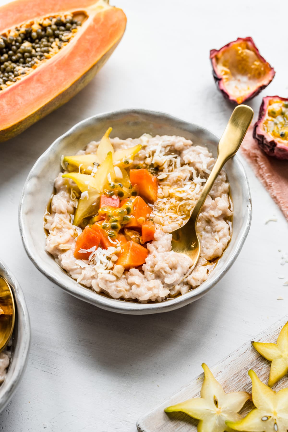 Overhead view of rice pudding in a bowl garnished with fruit and and shredded coconut.