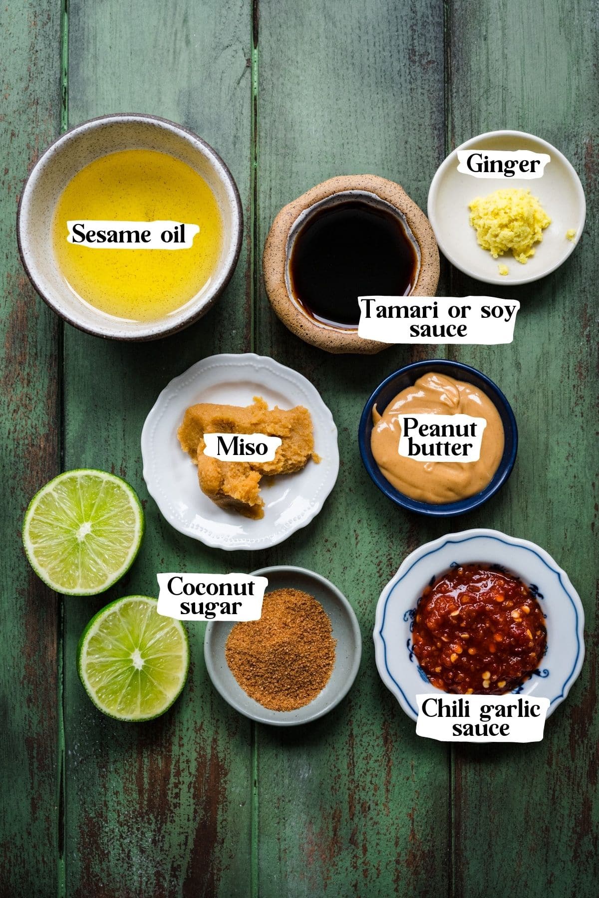 Overhead view of Thai salad dressing ingredients, including tamari, grated ginger, and sesame oil.