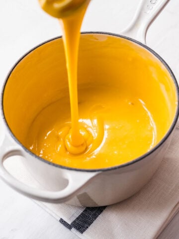 Overhead view of cheese sauce in a saucepan.