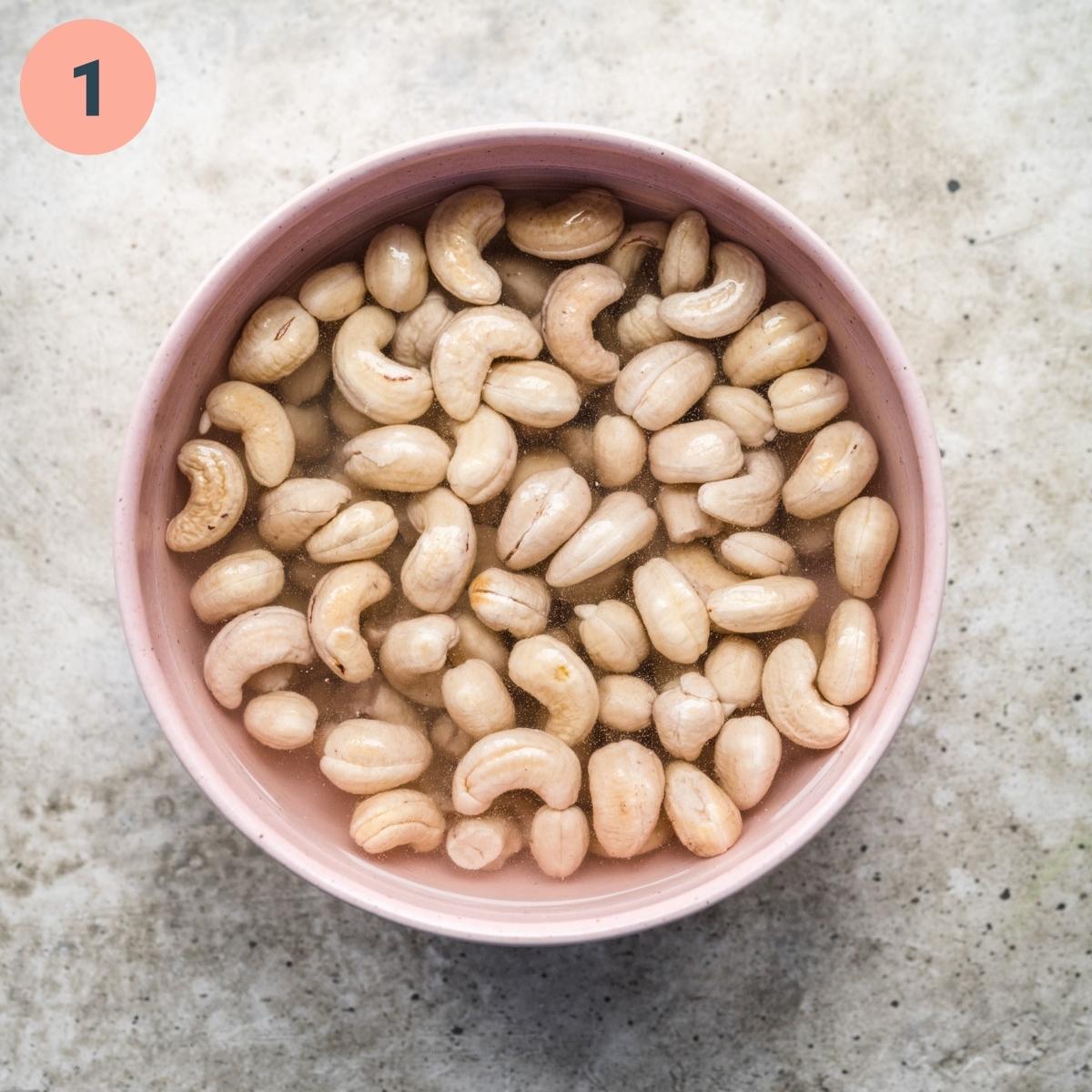 overhead view of cashews soaking in water. 