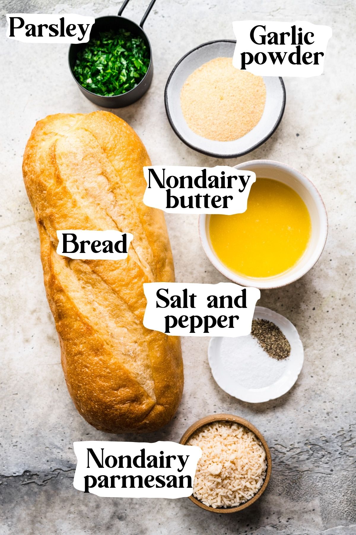 Overhead view of vegan garlic bread ingredients, including bread, nondairy butter, and garlic powder.