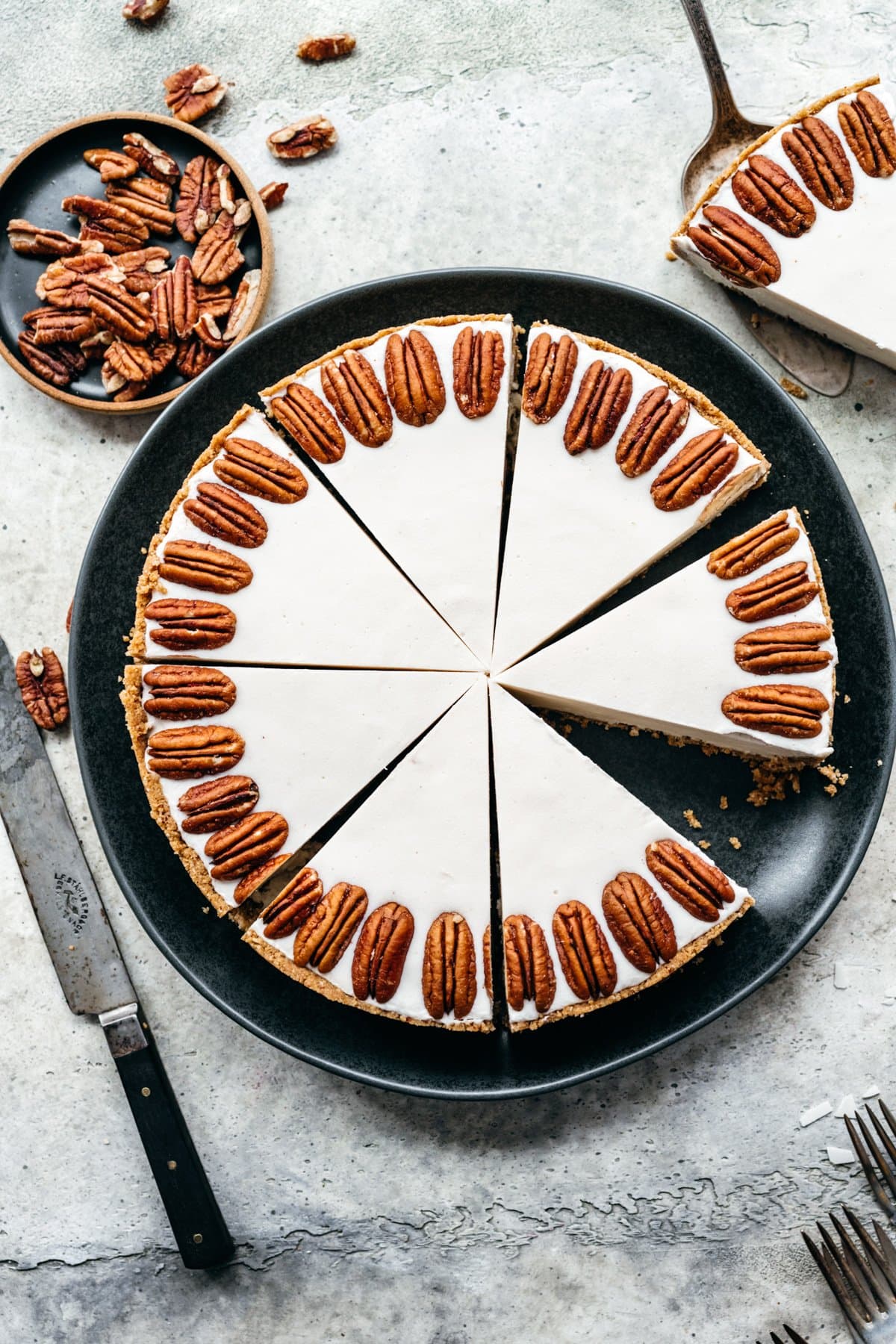 Overhead view of white chocolate cheesecake on a black tray.