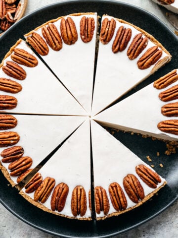 Overhead view of white chocolate cheesecake with pecans around the rim.