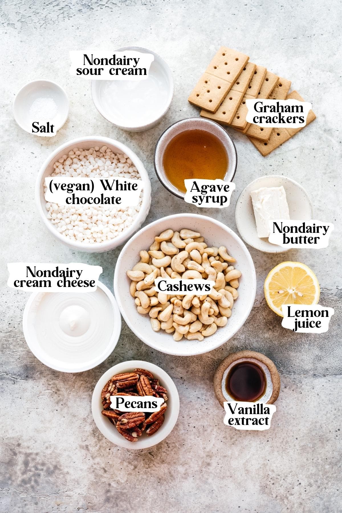 Overhead view of white chocolate cheesecake ingredients, including agave syrup, white chocolate chips, and cashews.