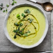 Overhead view of cauliflower leek soup garnished with herbs.