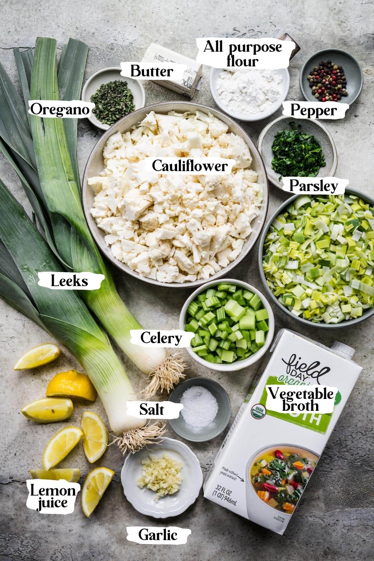 overhead view of ingredients for cauliflower leek soup in prep bowls with text labels. 