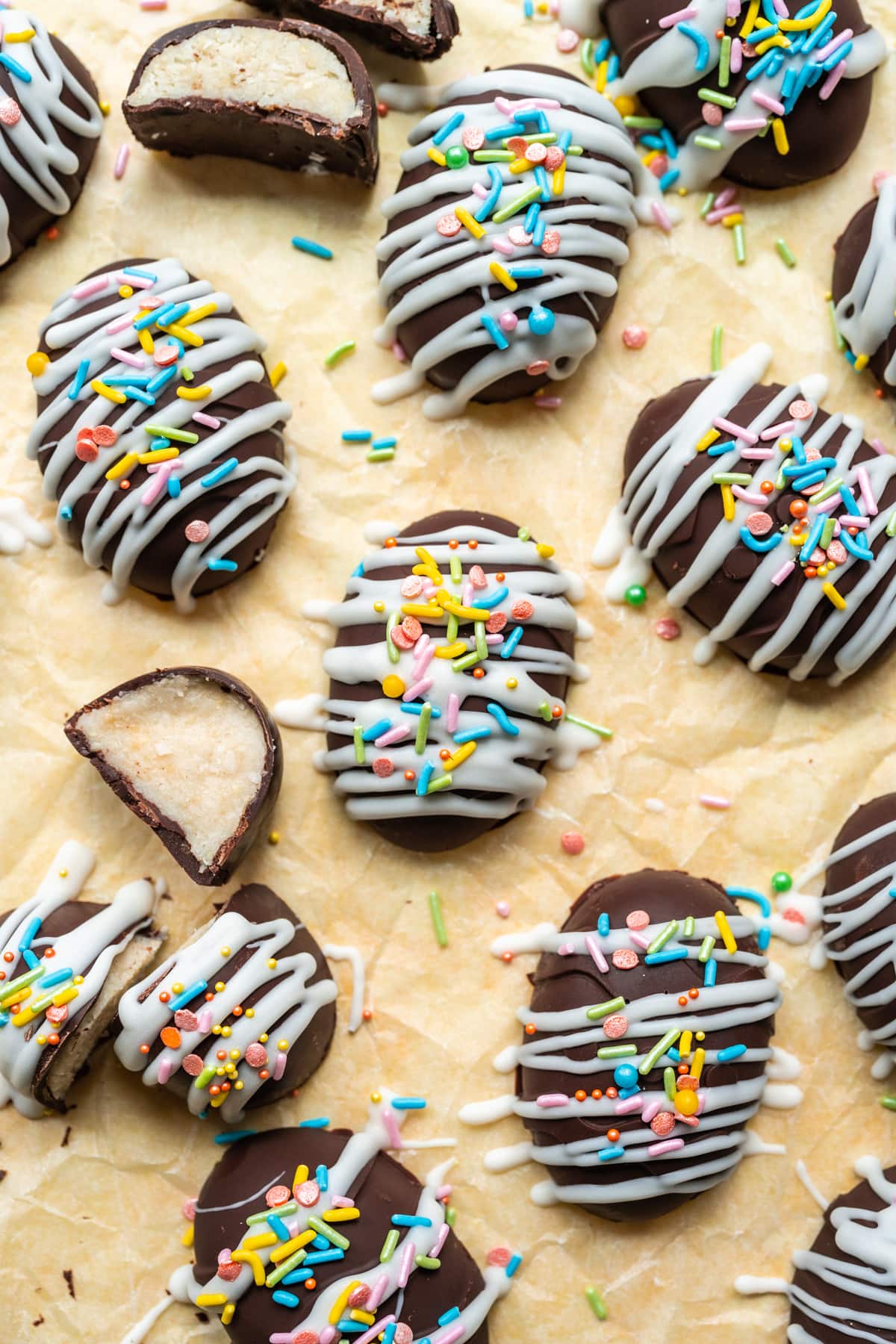 Chocolate coconut easter eggs with white chocolate and sprinkles on yellow backdrop.