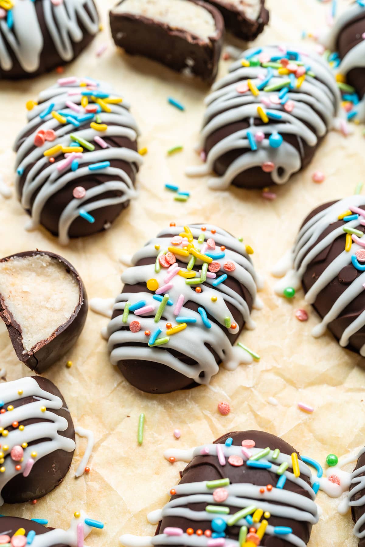 Chocolate coconut easter eggs with white chocolate and sprinkles on yellow backdrop.