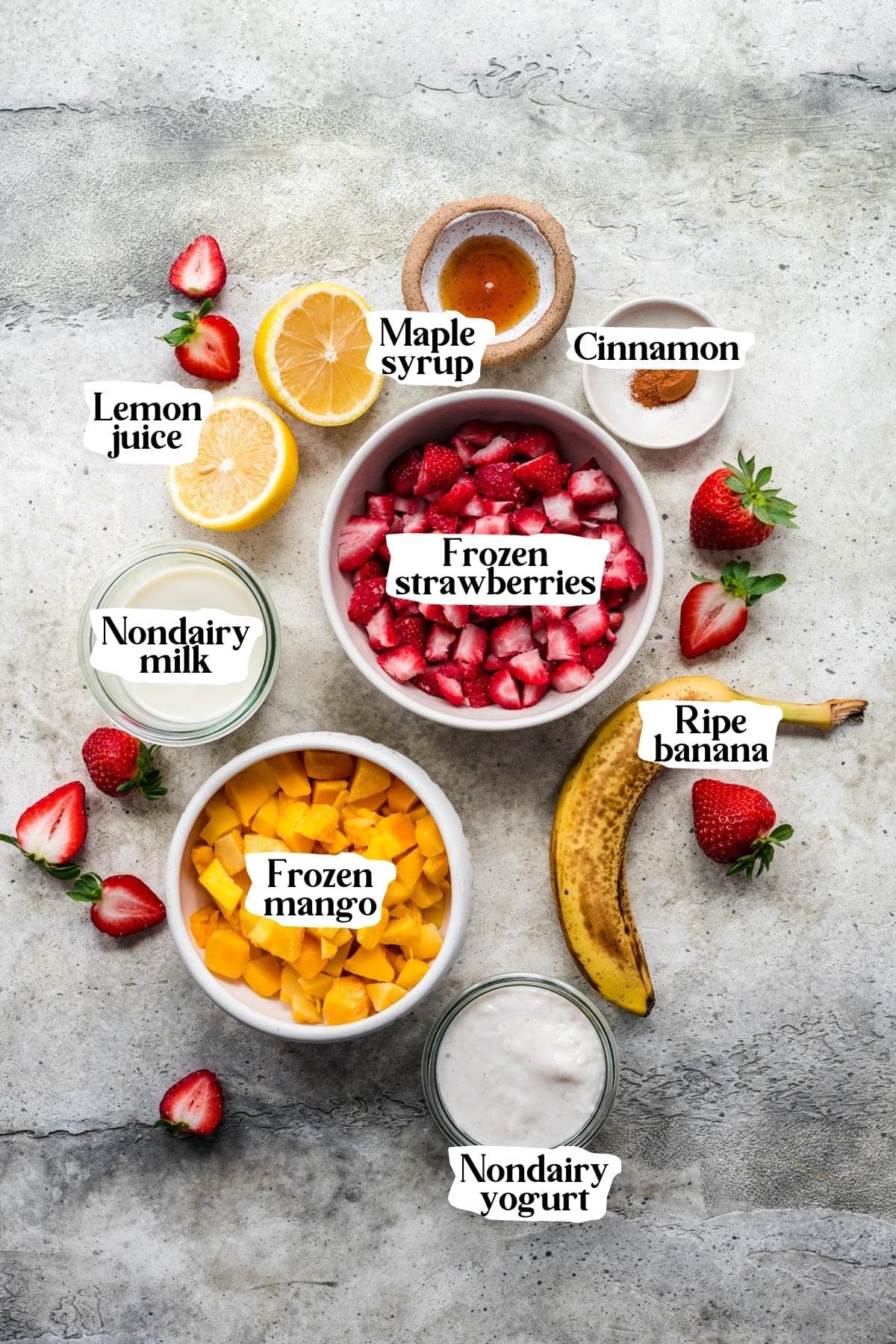 Overhead view of mango strawberry banana smoothie ingredients.