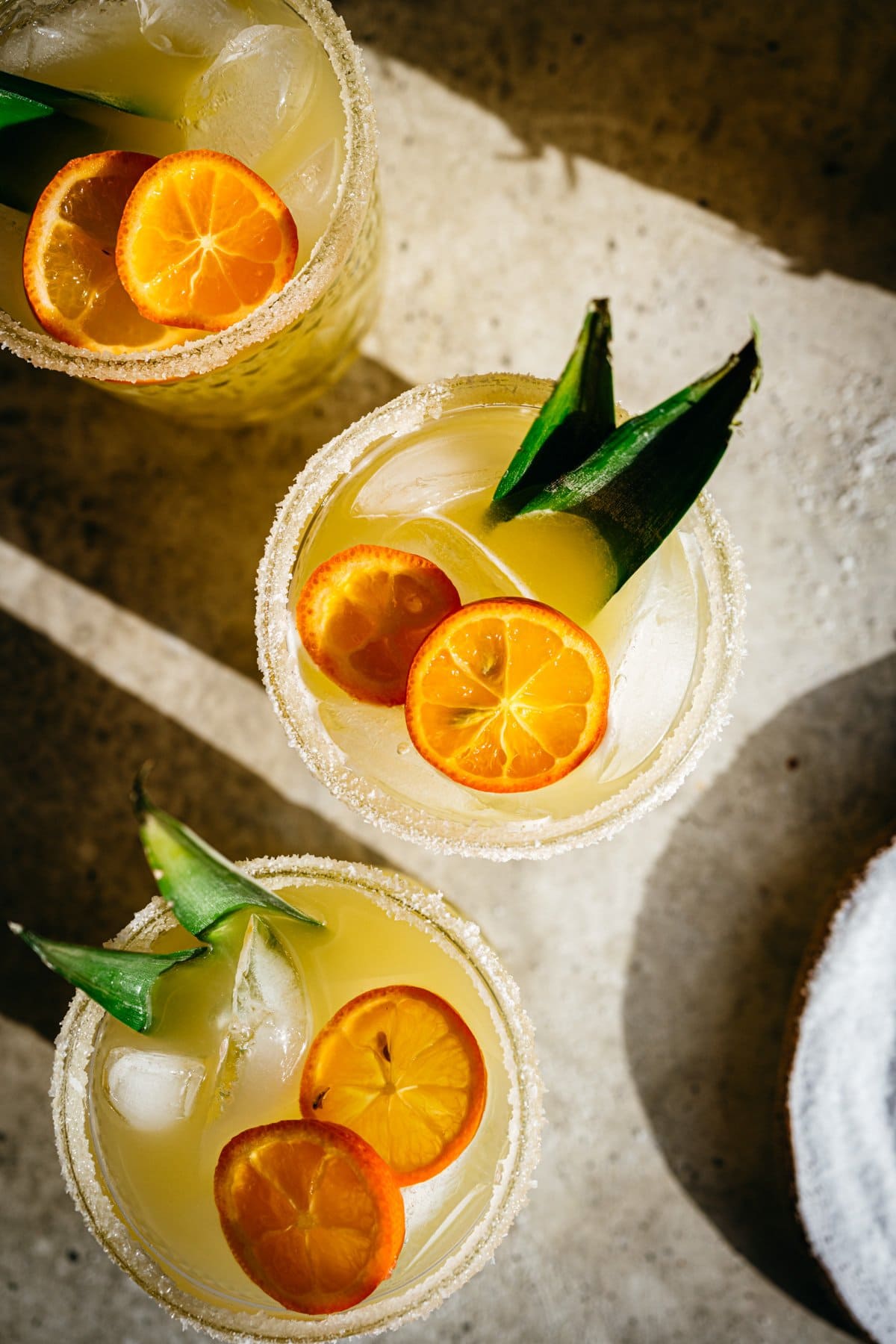 Overhead view of pineapple margarita in salt rimmed glass.