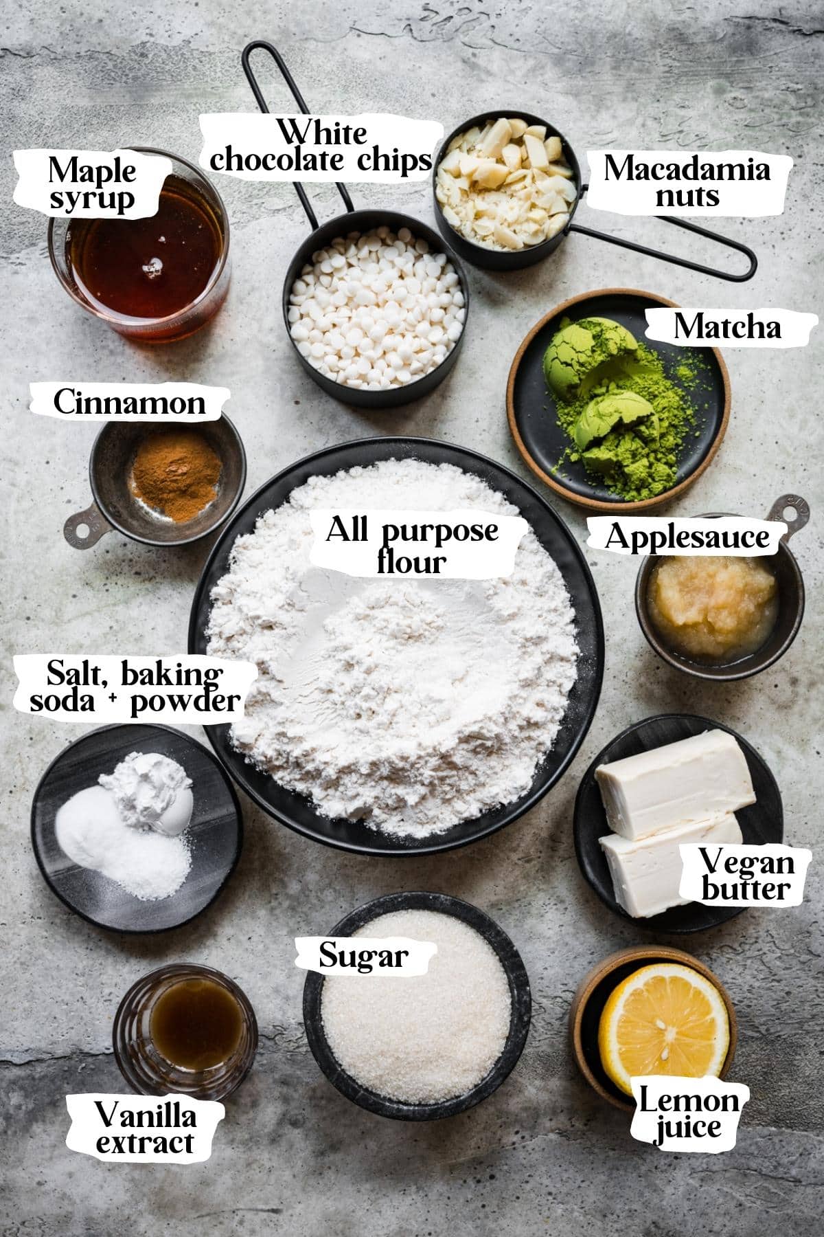 Overhead view of ingredients for vegan matcha cookies in small prep bowls with text labels. 