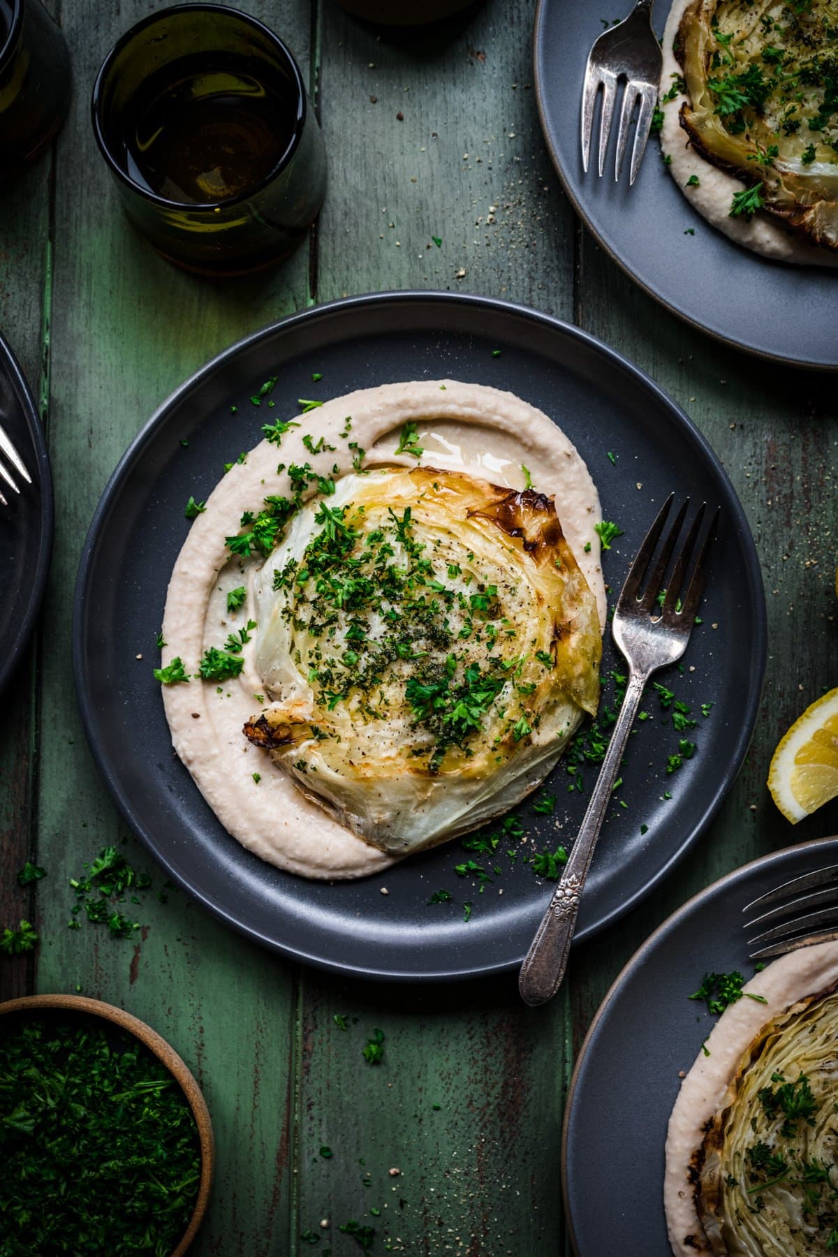 Overhead view of roasted cabbage steak on a plate with bean puree.