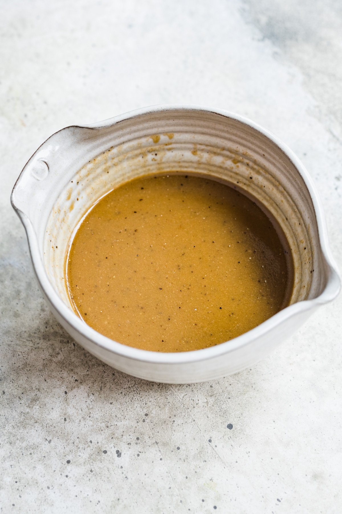 Overhead view of creamy balsamic dressing in a small bowl.