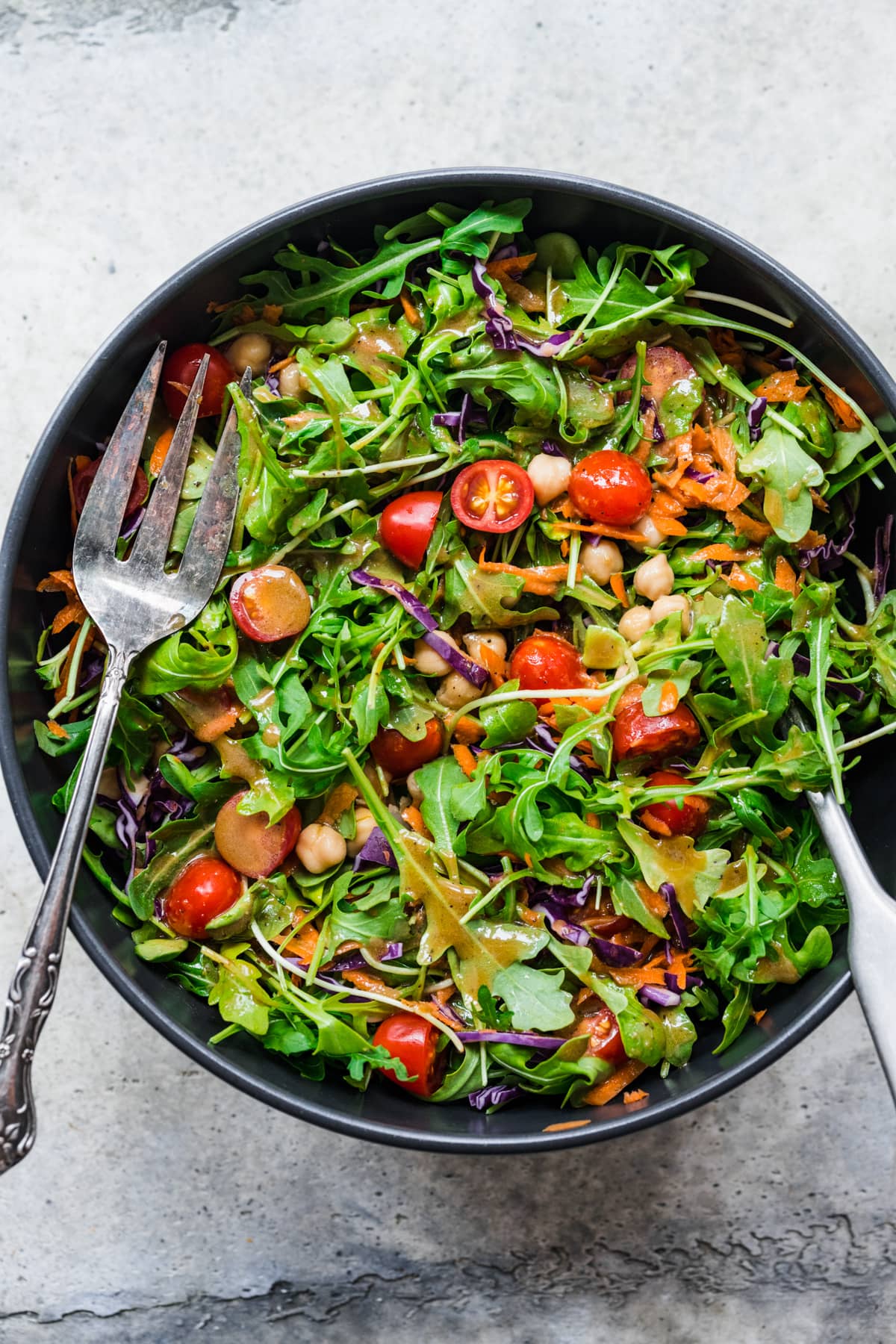 overhead view of green salad with balsamic dressing in salad bowl. 